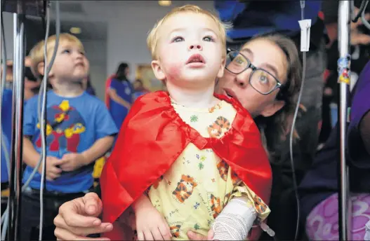  ?? ASSOCIATED PRESS ?? A child and his mother Ashley Lashum look out the window of a hospital. A new study says that ibuprofen can help treat chidren’s after-surgery pain without side-effects associated with oral morphine.