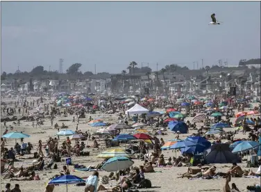  ?? MINDY SCHAUER — SOUTHERN CALIFORNIA NEWS GROUP ?? Hundreds of people gather in Newport Beach to cool off on a hot day despite the state’s stay at home orders on Saturday.