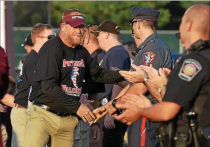  ?? AUSTIN HERTZOG - DIGITAL FIRST MEDIA ?? Pottsgrove head coach Bill Hawthorne shakes hands with emergency personnel on Military Appreciati­on Night at Pottsgrove on Aug. 24.