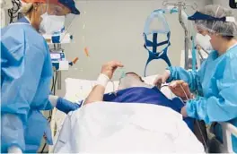  ?? ANTONIO CALANNI/AP ?? Hospital workers tend to a patient Thursday in Pope John XXIII Hospital’s COVID-19 intensive care unit in Bergamo, Italy.