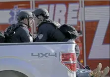  ?? John McCall/South Florida Sun-Sentinel via AP ?? Police officers ride in the back of a pickup truck as they tend to a victim following the shootings Wednesday in Parkland, Fla.