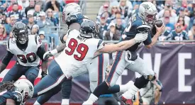  ?? MADDIE MEYER GETTY IMAGES ?? J.J. Watt of the Houston Texans attempts to tackle quarterbac­k Tom Brady, right, of the New England Patriots on Sunday in Foxborough, Mass. The Patriots won, 27-20.