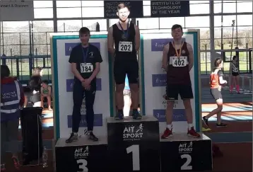  ??  ?? Karlis Kaugars on the podium for the high jump following his 1.70m winning leap. He later threw 15.97m in the Under-15 shot putt and had a championsh­ip best.