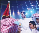  ??  ?? Kuwait’s Rajih Al-Hamidani (center), celebrates after winning the final of the televised program Million’s Poet on May 17, at Abu Dhabi’s Al-Raha Theatre. Apart from the glory, the Kuwaiti student took home five million dirhams ($1.36 million), the top...