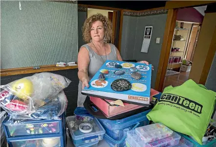  ?? MURRAY WILSON/STUFF ?? Manawatu¯ Canteen co-ordinator Jean Thomas sifts through years of young cancer patients’ mementoes as she packs up the Manawatu¯ branch.