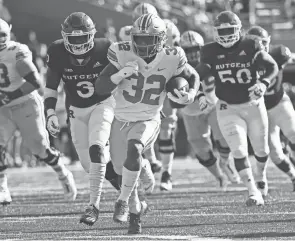  ?? JOSHUA A. BICKEL/COLUMBUS DISPATCH ?? Ohio State Buckeyes running back Treveyon Henderson (32) runs the ball during the first quarter of a NCAA Division I football game between the Rutgers Scarlet Knights and the Ohio State Buckeyes on Saturday at SHI Stadium in Piscataway, New Jersey.