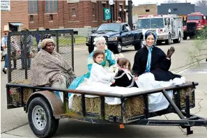  ?? Photos by Stan Shavers ?? ■ LEFT: The Hempstead County Riflemen take part in a parade commemorat­ing the bicentenni­al birthday of Hempstead County, Ark., on Saturday in Hope. ■ ABOVE: People wear period clothing in a parade float. The celebratio­n also included special speakers in the Univeristy of Arkansas at Hope’s Hempstead Hall: Some recounted personal stories of growing up in the county, while others discussed the area’s history.