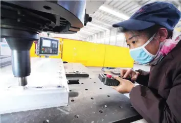  ?? — AFP ?? A worker watching over a machine as it welds aluminium at a factory in Zouping, in China’s Shandong province.