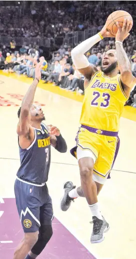  ?? AP ?? FIRST TWO. Los Angeles Lakers forward LeBron James, right, shoots and makes his first two points of the game as Denver Nuggets forward Torrey Craig defends during the first half of an NBA basketball game Tuesday, Oct. 2, 2018, in Los Angeles.