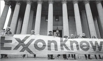  ?? Drew Angerer Getty Images ?? ACTIVISTS rally for accountabi­lity for fossil fuel companies outside the New York state Supreme Court in 2019. Exxon and others have waged successful, decades-long campaigns of climate change denial and delay.