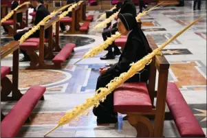  ?? The Associated Press ?? ST. PETER’S BASILICA: A nun sitting by a palm branch attends the Pope’s Palm Sunday Mass behind closed doors in St. Peter’s Basilica on Sunday at the Vatican during the lockdown aimed at curbing the spread of the COVID-19 infection caused by the novel coronaviru­s.