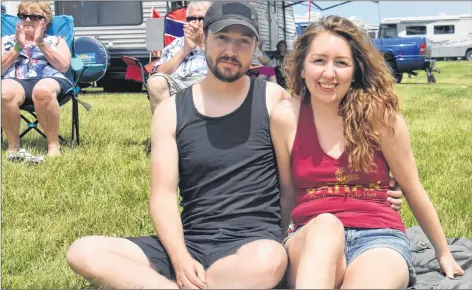  ?? TONY DAVIS/ THE GUARDIAN ?? Natasha Pentyliuk and Colin Bodor sit in the grass enjoying the Bluegrass and Old Time Music Festival this past Sunday. The couple stumbled upon the festival while Pentyliuk was visiting P.E.I. taking a break from her work in Yarmouth, N.S.