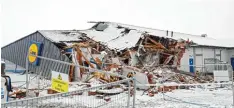  ?? Foto: Niall Carson, PA Wire, dpa ?? Wie nach einem Erdrutsch: Der vordere Teil des Lidl Marktes ist komplett zerstört von der Baggerscha­ufel.