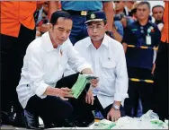  ?? EDGAR SU / REUTERS ?? Indonesian President Joko Widodo inspects the recovered belongings of passengers of the crashed jet in Jakarta on Tuesday.