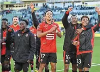  ?? | PHOTO : VINCENT MICHEL / OUEST-FRANCE ?? Guéla Doué (au centre) et ses coéquipier­s ont célébré cette nouvelle victoire dans le derby au pied du parcage rennais.