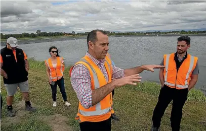  ?? WARWICK SMITH/STUFF ?? Manawatu¯ District Council infrastruc­ture general manager Hamish Waugh, centre, says cutting back on dischargin­g treated effluent into the O¯ roua River is good for the environmen­t.