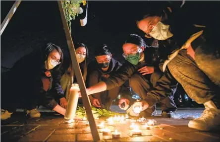  ?? Photograph­s by Allen J. Schaben Los Angeles Times ?? MOURNERS hold a vigil Monday for the 11 victims of Saturday’s mass shooting at Star Ballroom Dance Studio in Monterey Park.