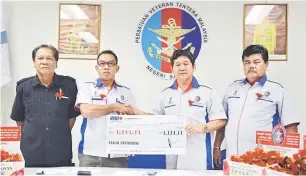  ??  ?? DERMA: Thomas (dua kanan) menerima sumbangan daripada Mohd Bakri, mewakili Farah Enterprise yang menyumbang dana sebanyak RM1,111 kepada Kempen Tabung Pahlawan 2014.