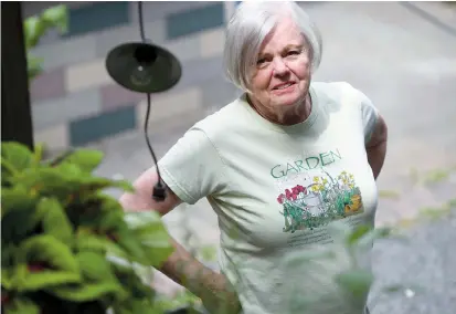  ??  ?? Anne Hunt stands in her garden at her home in Chicago. Since Hunt’s Alzheimer’s diagnosis in 2016, she has started gardening as a form of therapy. — IC