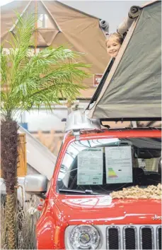  ?? FOTO: DPA ?? Lucie im Dachzelt auf einem Auto von Autohome: Der Trend auf dem Caravan-Salon geht zu kleineren und kompaktere­n Fahrzeugen.
