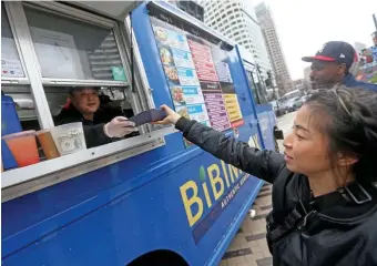 ?? MATT sTONE pHOTOs / BOsTON HErAld ?? WHEELIN’ & DEALIN’: Justin Won, owner of the Bibim Box food truck, hands a meal to Jessie Lee in Dewey Square on Friday. Below left, Jonathan Dore enjoys a meal from Bibim Box steps away from the truck, and to the right, Phanna Ky, manning the Chicken & Rice Guys food druck, explains the sauces on display.