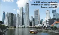  ??  ?? A RIVER taxi boat ply along the river next to the financial district in Singapore on June 29.