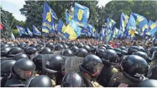  ?? AFP ?? Activists of a few radical Ukrainian parties clash with police officers in front of the parliament in Kiev on Monday.