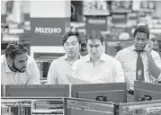  ?? Mark Lennihan / Associated Press ?? Traders work this month on the Mizuho Americas trading floor in New York.