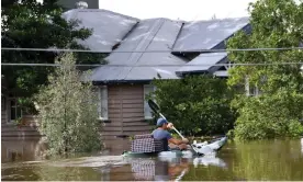  ?? Darren England/AAP ?? A man paddling a kayak through flood waters in Brisbane, Australia, in 2022. Photograph: