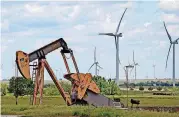  ?? [PHOTO BY BRYAN TERRY, THE OKLAHOMAN ARCHIVES] ?? Wind turbines behind a pump jack are seen just east of Okarche.