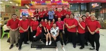  ?? ?? Wee (back, fifth left) joins the staff members at SCR Xpress in Emart Tabuan Jaya Mall in a group photo after the draw.