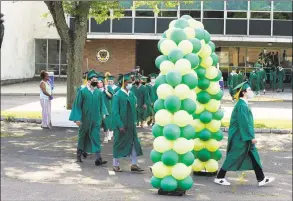  ?? Matthew Brown / Hearst Connecticu­t Media ?? Members of the Class of 2020 walk through an archway of balloons as Trinity Catholic High School celebrates its final graduation ceremony on Thursday in Stamford.