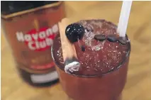  ??  ?? The Cuba libre 2.0. is topped with a back cherry, a burning cinnamon stick and coffee beans.