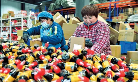  ?? ?? Workers pack bottled condiment at an industrial park in Laoling, east China’s Shandong Province. — Xinhua