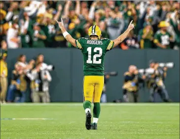  ?? DYLAN BUELL / GETTY IMAGES ?? Packers quarterbac­k Aaron Rodgers enjoys the moment after throwing a touchdown pass in the fourth quarter of Sunday night’s comeback win over the Bears at Lambeau Field.