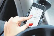  ?? FOTO: DPA ?? Die Navigation­s-App auf dem Handy darf der Fahrer bei laufendem Motor nur bedienen, wenn das Gerät in einer Halterung steckt.