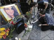  ?? CURTIS COMPTON / AP ?? Stephen Friedrich (front) and Scott Douglas set out candles for Heather Heyer at Woodruff Park on Sunday in Atlanta. Protesters decrying hatred and racism converged around the country on Sunday.