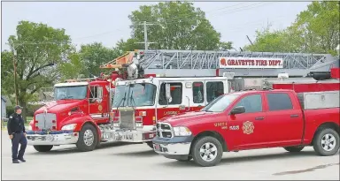  ?? Westside Eagle Observer/SUSAN HOLLAND ?? A trio of Gravette Fire Department vehicles lines up on the south side of the parking lot at CV’s Family Foods to serve as a backdrop for the department’s second annual 911 remembranc­e ceremony.