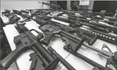  ?? DAMIAN DOVARGANES/AP ?? IN THIS DEC. 27, 2012, FILE PHOTO, a variety of military-style semi-automatic rifles obtained during a buy back program are displayed at Los Angeles police headquarte­rs.