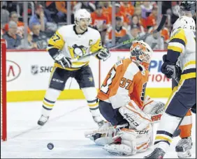  ?? AP PHOTO ?? The puck bounces back out of the net behind Philadelph­ia Flyers goalie Brian Elliott after Pittsburgh Penguins’ Justin Schultz, not pictured, scored a power play goal during the third period in Game 3 of their first-round series Sunday in Philadelph­ia.