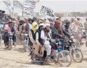  ?? TARIQ ACHKZAI/AP ?? Taliban supporters carry their signature white flags July 14 after the Taliban said they seized the Afghan border town of Spin Boldak across from Chaman, Pakistan. The Taliban want President Ashraf Ghani removed from office.