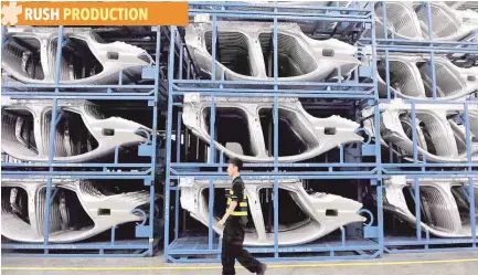  ??  ?? A security guard walks inside a car factory in Shenyang, Liaoning Province, China. — Reuters