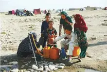  ?? AP ?? Internally displaced Afghan children collect water from a public water tap at a camp in Mazar-e-Sharif.