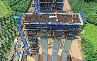  ?? WANG HUABIN / FOR CHINA DAILY ?? Workers construct a railway bridge on the Hangzhou-Wenzhou high-speed railway line in Taizhou, Zhejiang province.