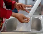  ?? Reuters ?? HELPING HAND: A woman gets rice from a 24/7 automatic rice dispensing machine during the outbreak of the coronaviru­s disease in Ho Chi Minh City. —