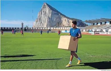  ?? ERASMO FENOY ?? Óscar Arroyo, que apunta a titular, carga un cajón de madera durante un entrenamie­nto.