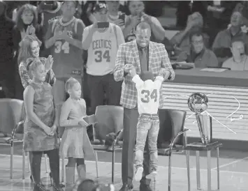  ?? ASSOCIATED PRESS ?? Former Boston Celtics Paul Pierce, center, stands with his family during a ceremony to retire his number following an NBA basketball game against the Cleveland Cavaliers in Boston.