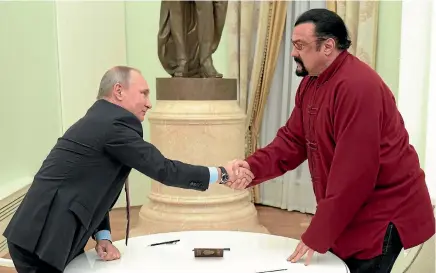  ?? REUTERS ?? Russia’s President Vladimir Putin shakes hands with US actor Steven Seagal at the Kremlin in Moscow.