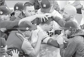  ?? AP/ERIC GAY ?? Alex Bregman (center) of the Houston Astros is mobbed by teammates after driving in Derek Fisher with the game-winning run in the 10th inning to give the Astros a 13-12 victory over the Los Angeles Dodgers in Game 5 of the World Series on Sunday night.