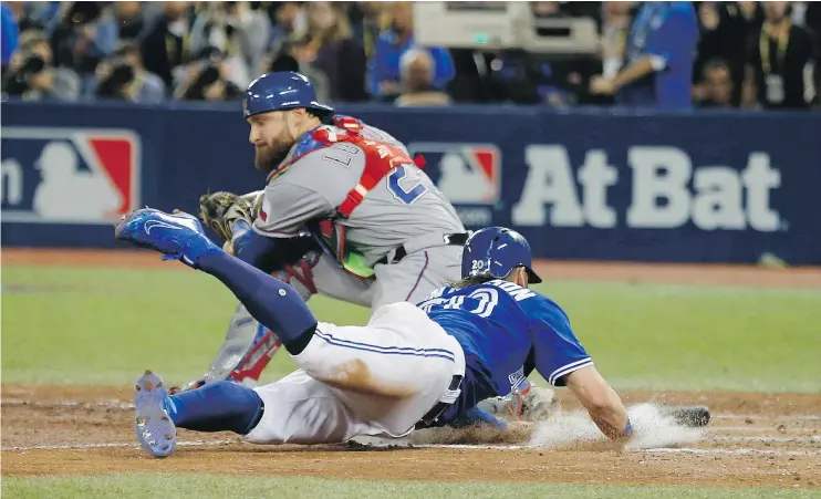  ?? JACK BOLAND/PNG FILES ?? Toronto Blue Jays’ Josh Donaldson beats the throw to Texas Rangers’ Jonathan Lucroy in the 10th inning to win Game 3 of the ALDS in Toronto on Sunday.